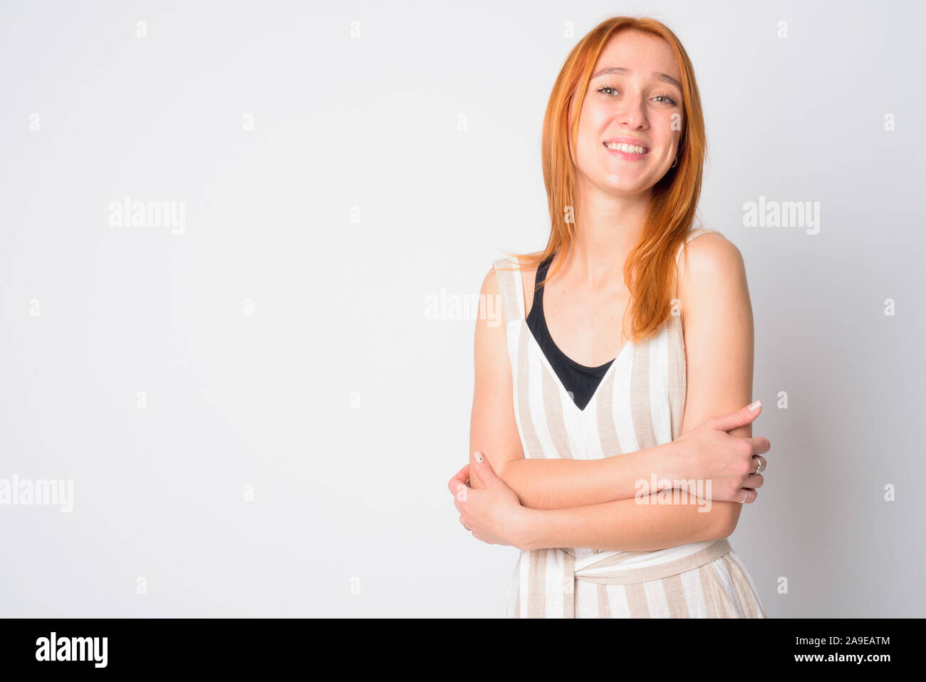 Ritratto di felice giovane bella redhead donna sorridente con le braccia incrociate Foto Stock