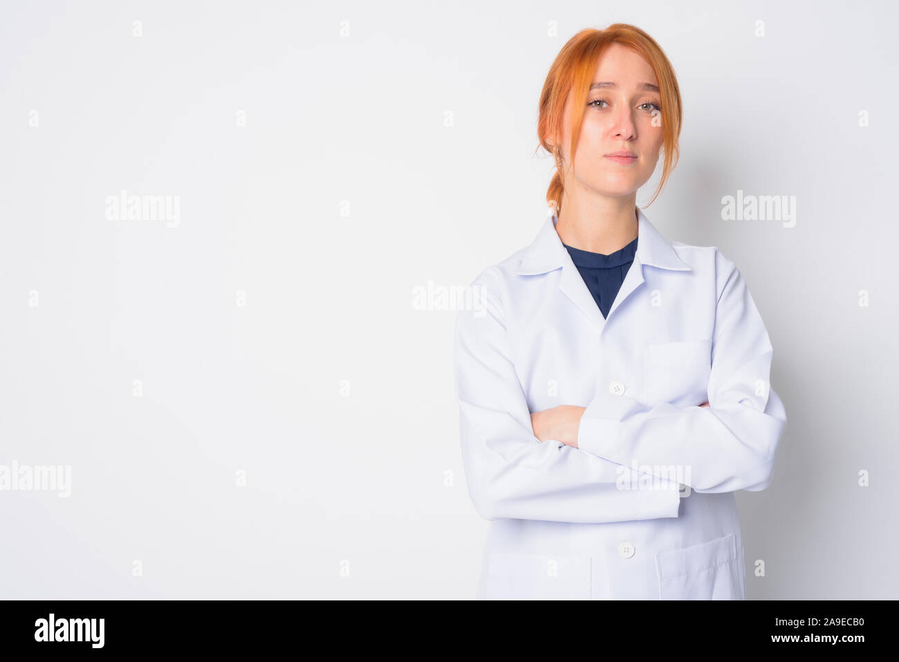 Ritratto di giovane bella donna redhead medico con le braccia incrociate Foto Stock