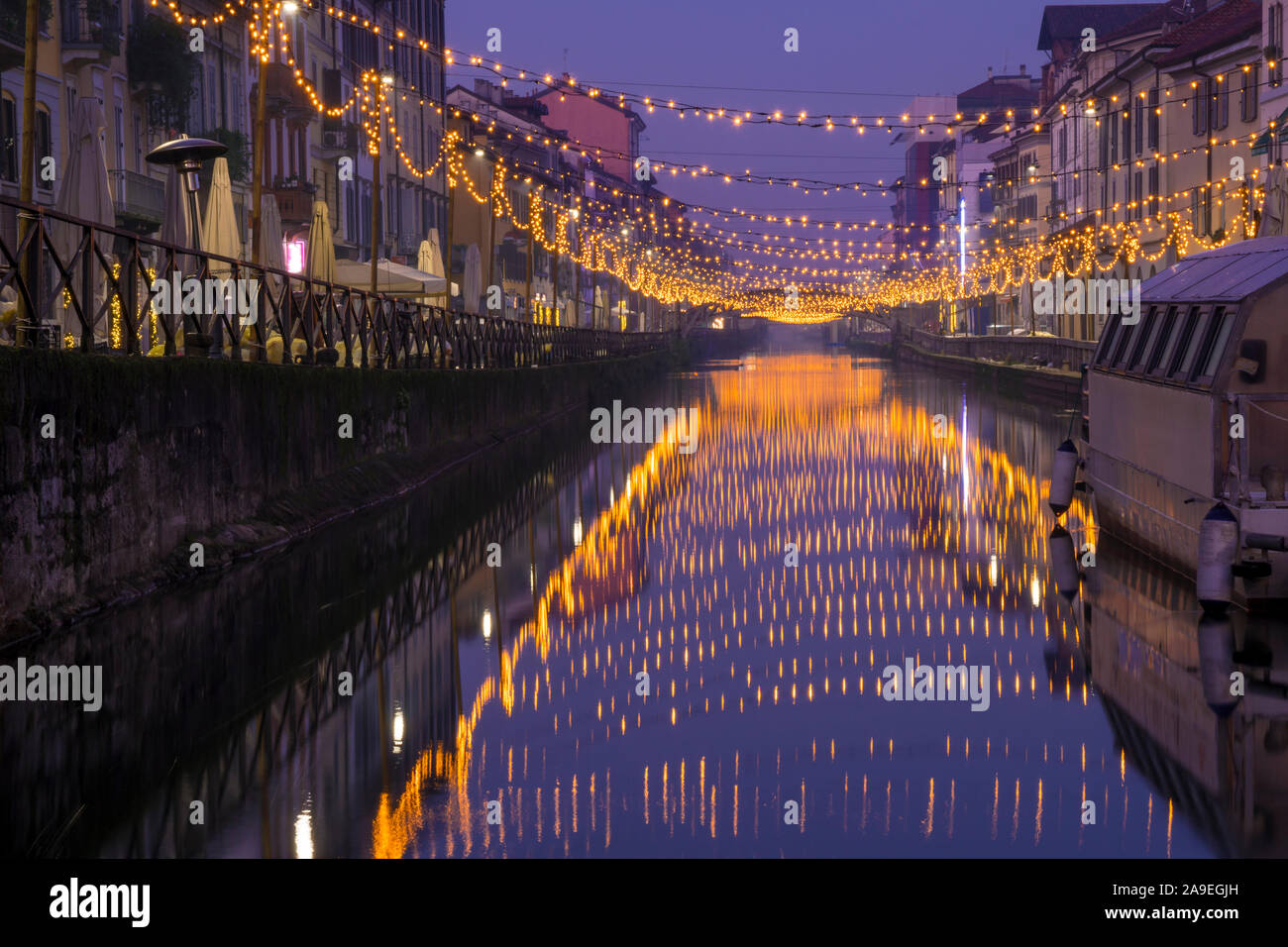 Vista notturna del Naviglio Grande canal per via navigabile in Milano, Italia. Le luci di Natale sono riflessi sull'acqua. Foto Stock