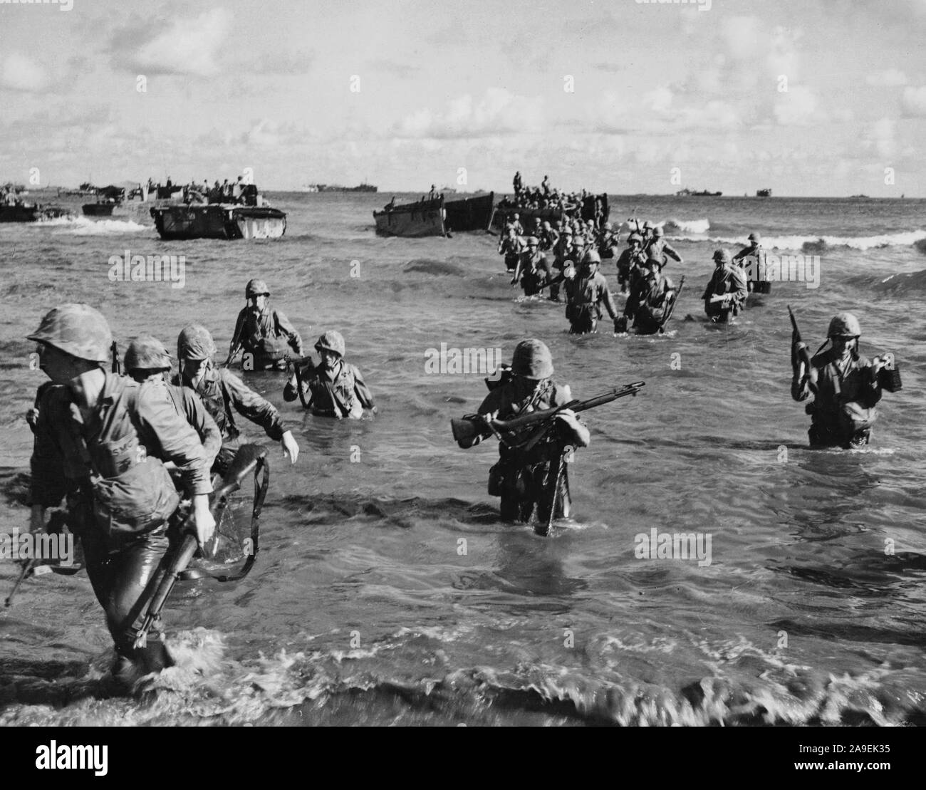 Marines wade a terra da una chiatta di atterraggio sulla isola di Tinian. Presa dopo 9 giorni di combattimenti. Foto Stock