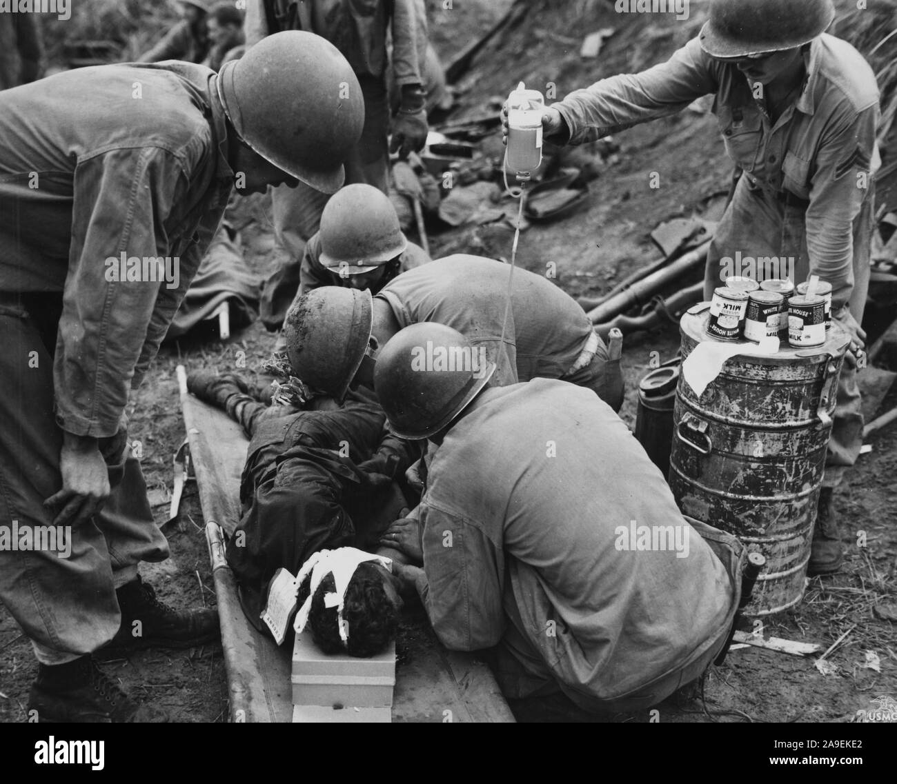 Gravemente ferito muore marini come corpsmen erano circa per amministrare il plasma sanguigno per lui. La battaglia di Guam. Foto Stock