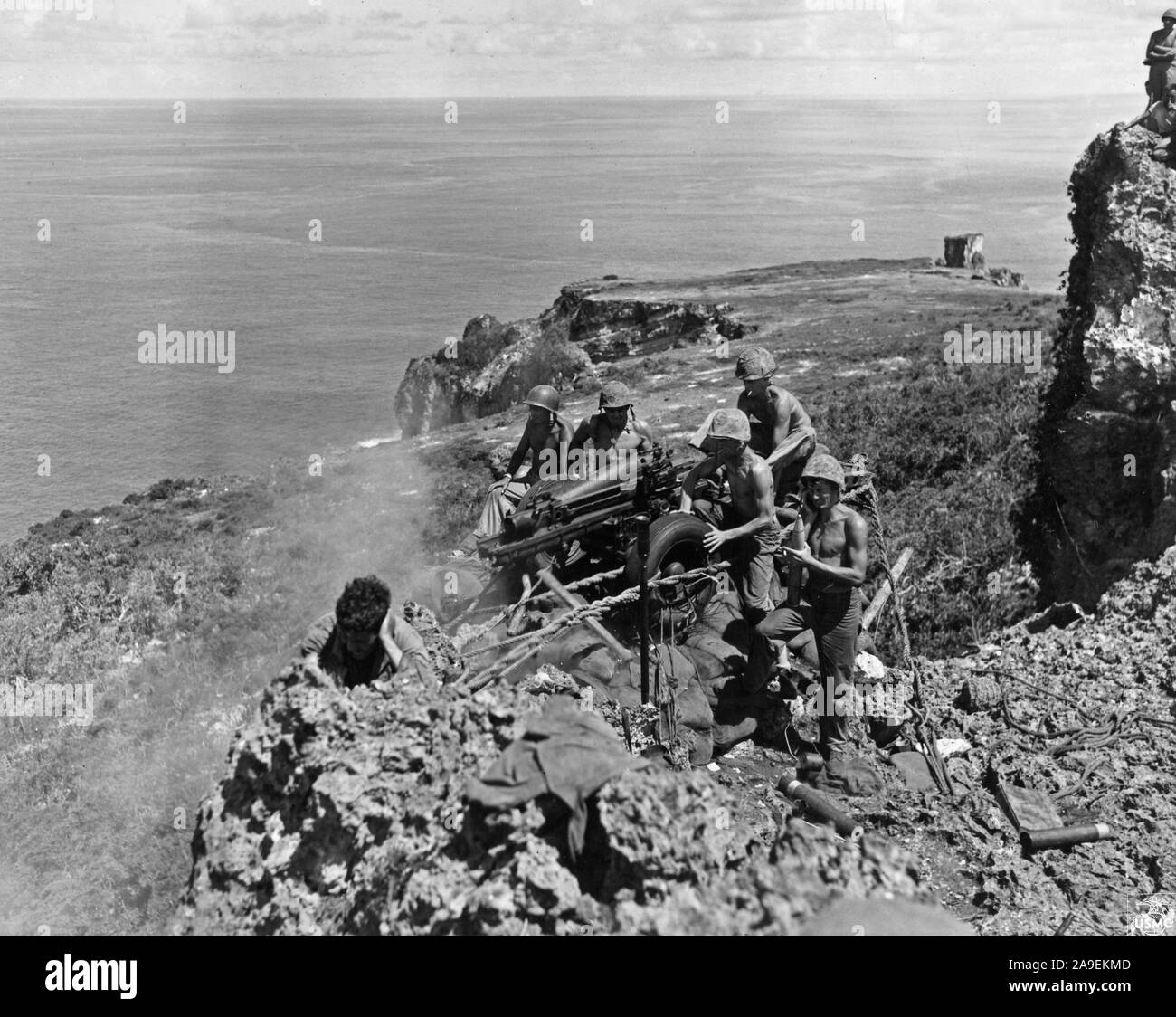 8 25 1944 marines manning un campo obice blast un nido Giapponesi in una grotta dal bordo di una scogliera a strapiombo su Tinian Foto Stock