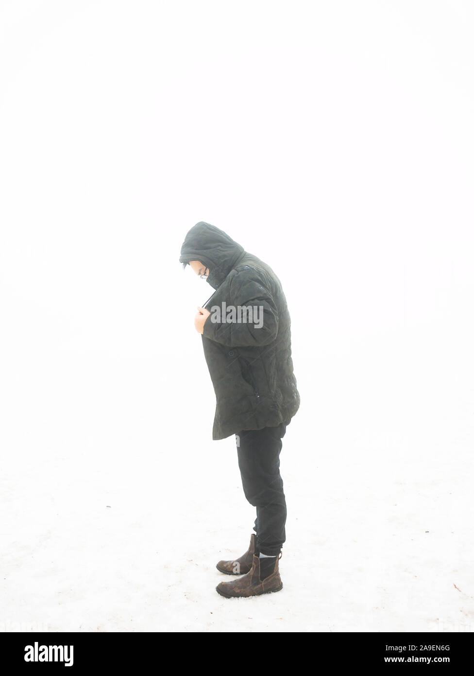 Un uomo che indossa una giacca calda in inverno nevoso giorno. Lonely nella neve. La stagione fredda Foto Stock