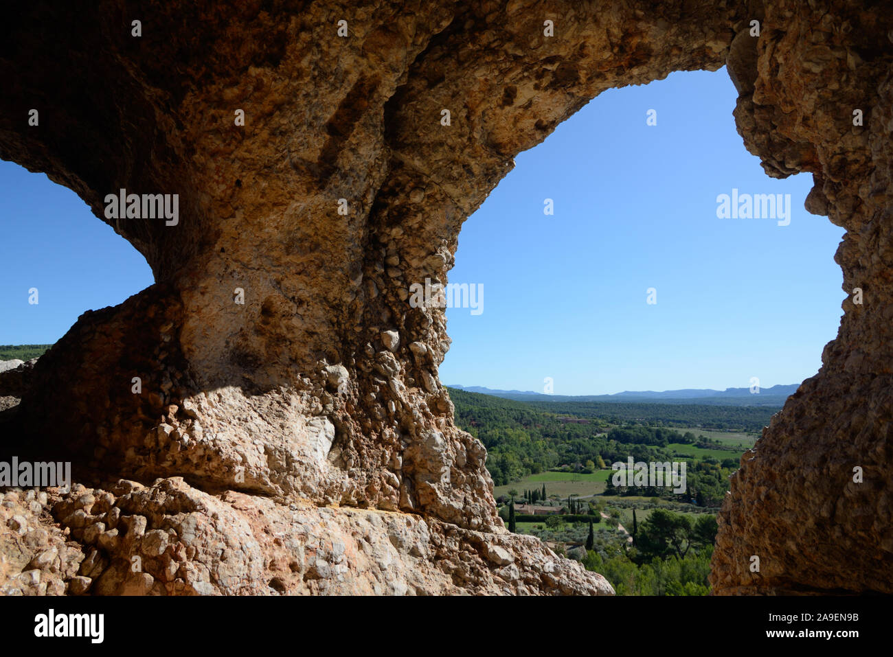 Vista attraverso La Roche Percée o roccia bucata oltre la campagna provenzale Mont Sainte-Victoire Riserva Naturale nr Aix-en-Provence Provenza Foto Stock