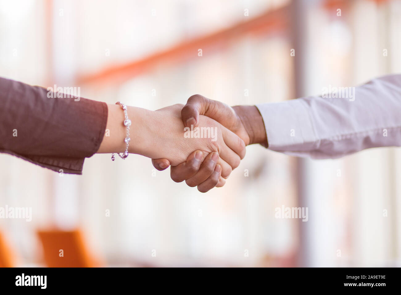 Stretta di mano tra africani e di un uomo caucasico. Foto Stock