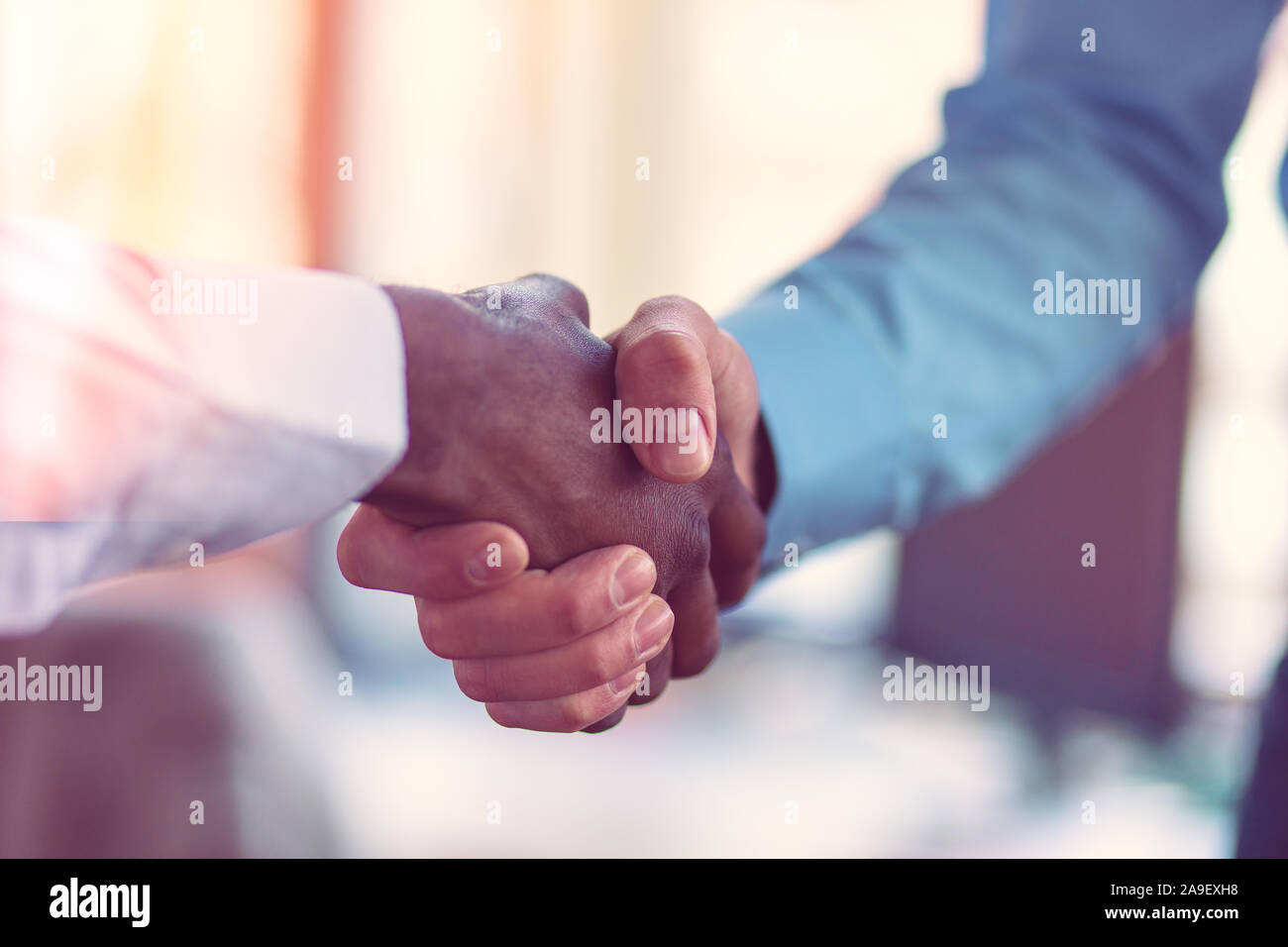 Stretta di mano tra africani e di un uomo caucasico. Foto Stock