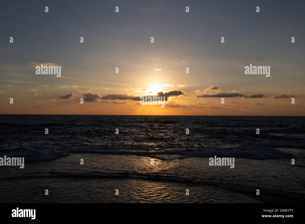 Godendo l'ultima luce del giorno con la fantastica vista del mare e i colori del tramonto rendono nel cielo Foto Stock