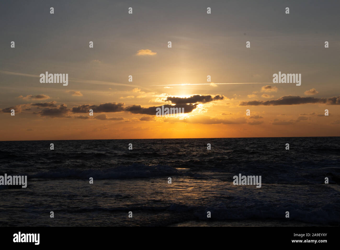 Godendo l'ultima luce del giorno con la fantastica vista del mare e i colori del tramonto rendono nel cielo Foto Stock