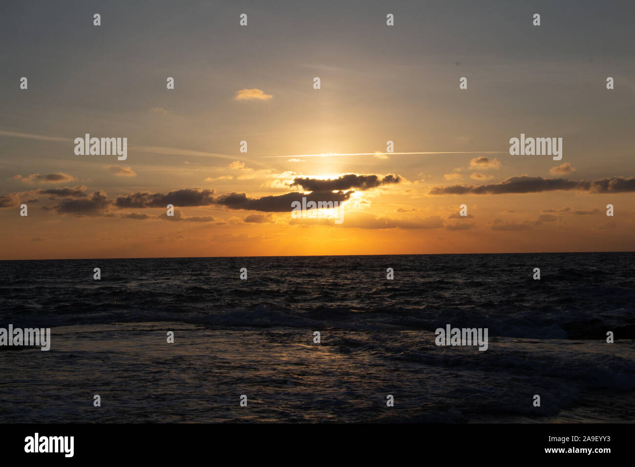 Godendo l'ultima luce del giorno con la fantastica vista del mare e i colori del tramonto rendono nel cielo Foto Stock