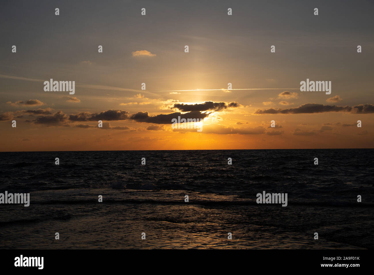 Godendo l'ultima luce del giorno con la fantastica vista del mare e i colori del tramonto rendono nel cielo Foto Stock