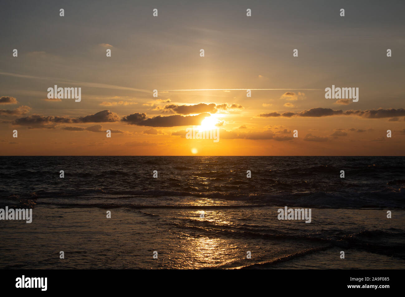 Godendo l'ultima luce del giorno con la fantastica vista del mare e i colori del tramonto rendono nel cielo Foto Stock