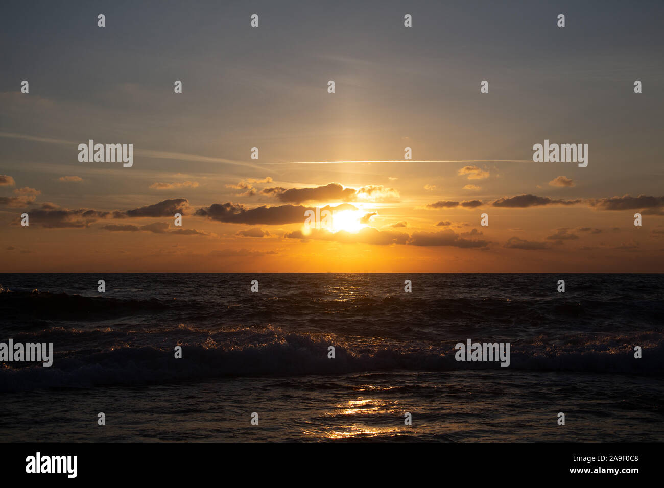 Godendo l'ultima luce del giorno con la fantastica vista del mare e i colori del tramonto rendono nel cielo Foto Stock