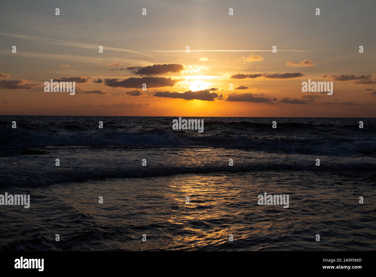 Godendo l'ultima luce del giorno con la fantastica vista del mare e i colori del tramonto rendono nel cielo Foto Stock