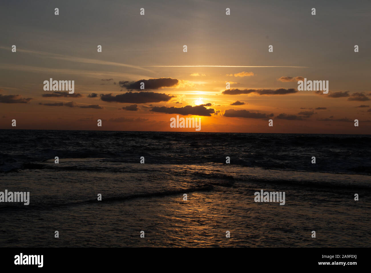 Godendo l'ultima luce del giorno con la fantastica vista del mare e i colori del tramonto rendono nel cielo Foto Stock