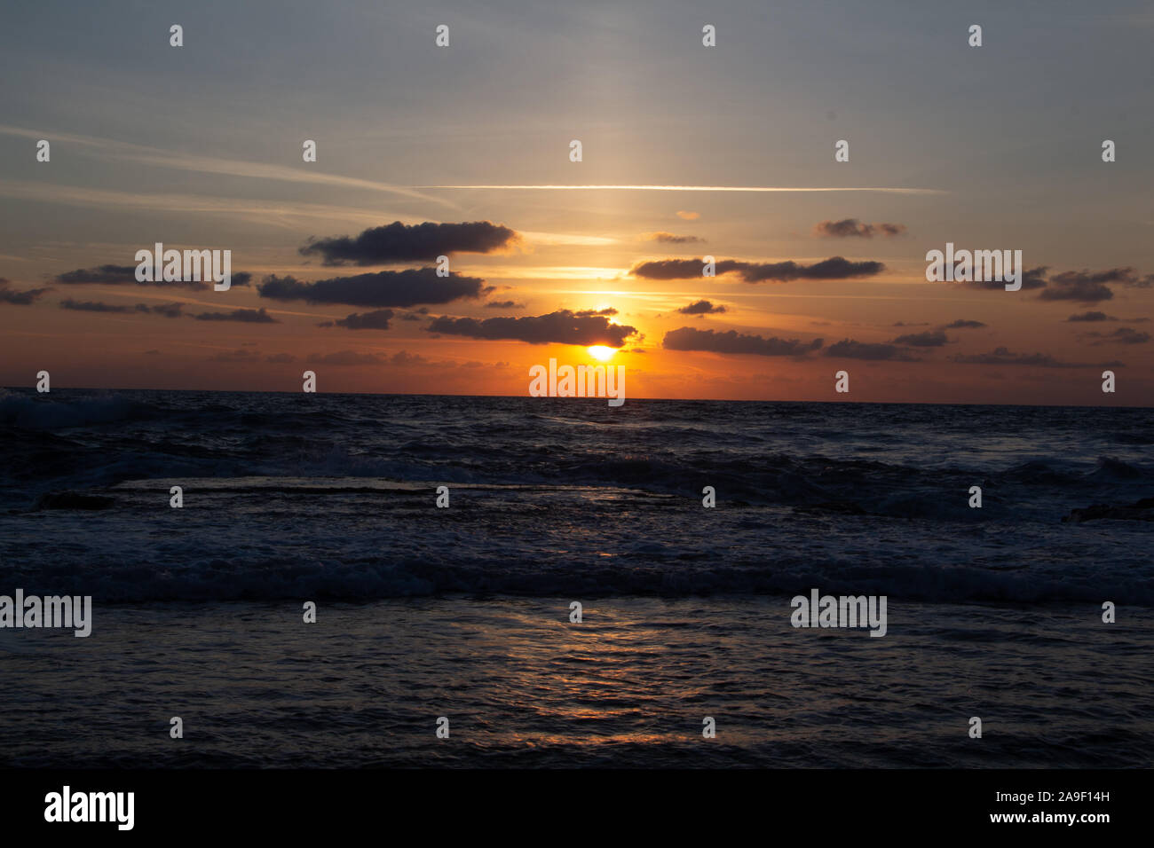 Godendo l'ultima luce del giorno con la fantastica vista del mare e i colori del tramonto rendono nel cielo Foto Stock