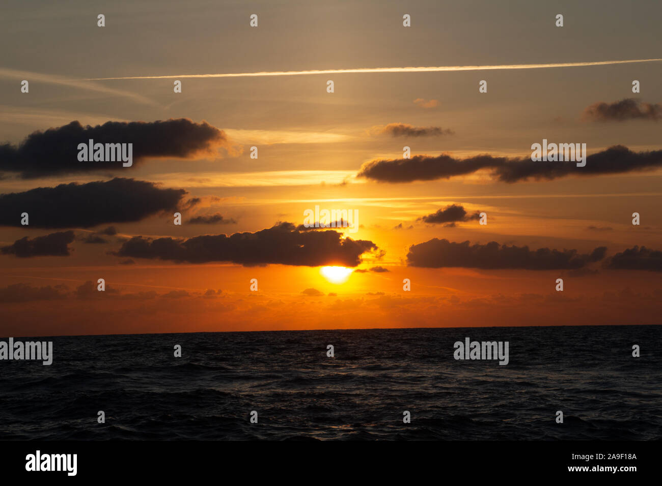 Godendo l'ultima luce del giorno con la fantastica vista del mare e i colori del tramonto rendono nel cielo Foto Stock