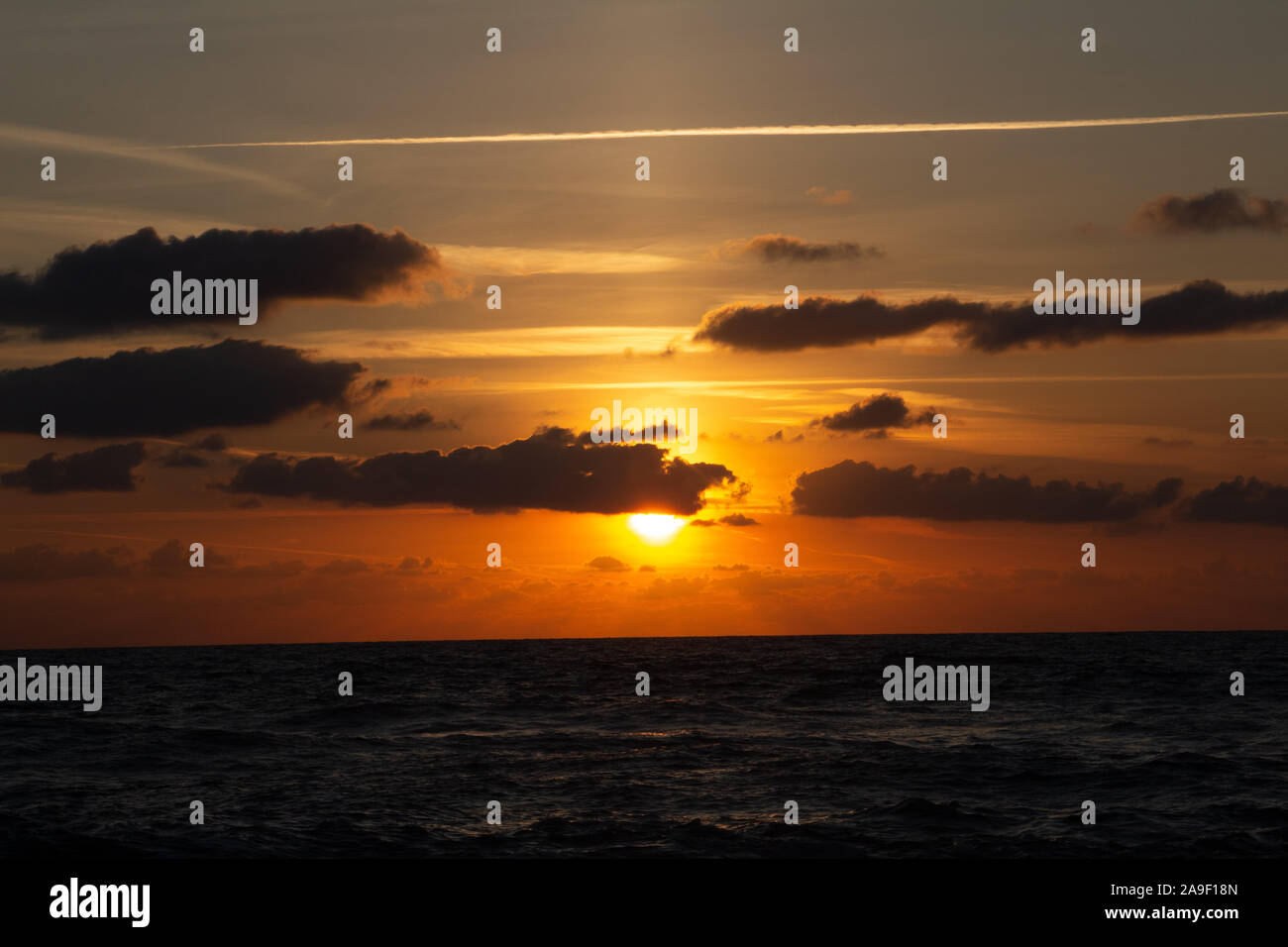 Godendo l'ultima luce del giorno con la fantastica vista del mare e i colori del tramonto rendono nel cielo Foto Stock