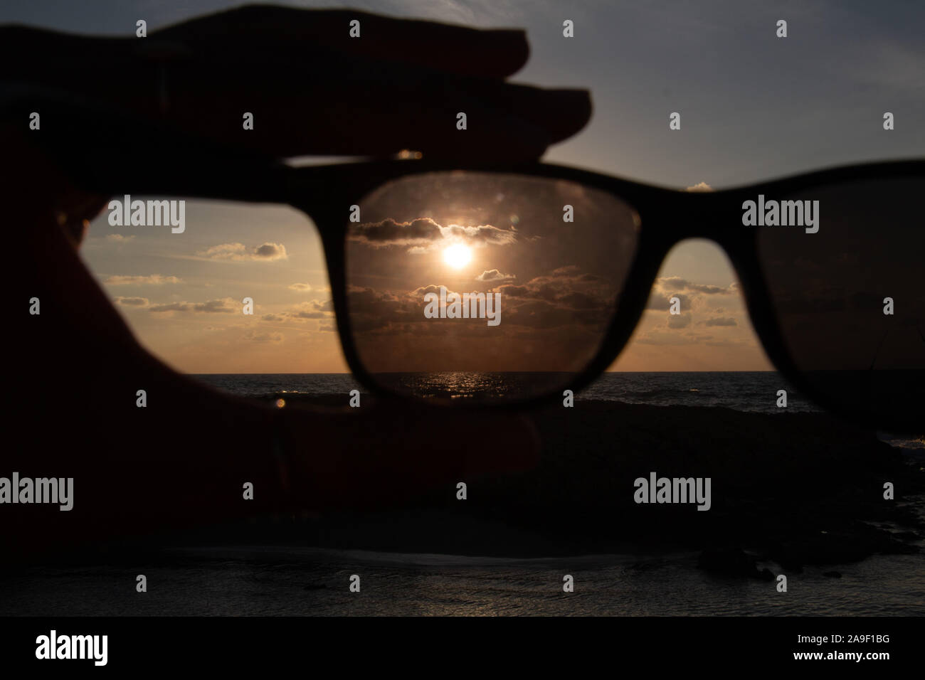 Godendo l'ultima luce del giorno con la fantastica vista del mare e i colori del tramonto rendono nel cielo Foto Stock