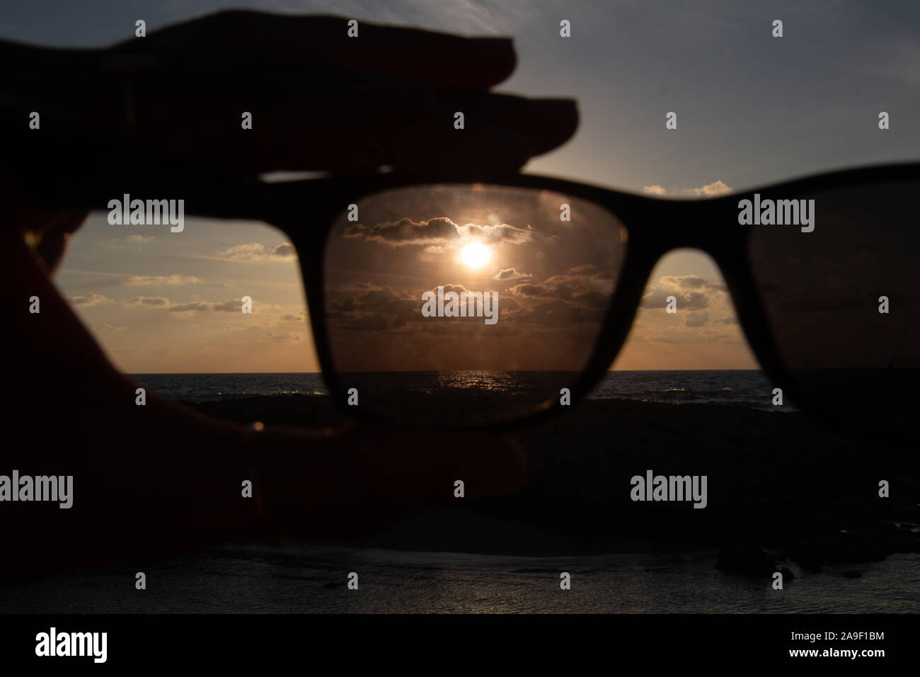 Godendo l'ultima luce del giorno con la fantastica vista del mare e i colori del tramonto rendono nel cielo Foto Stock