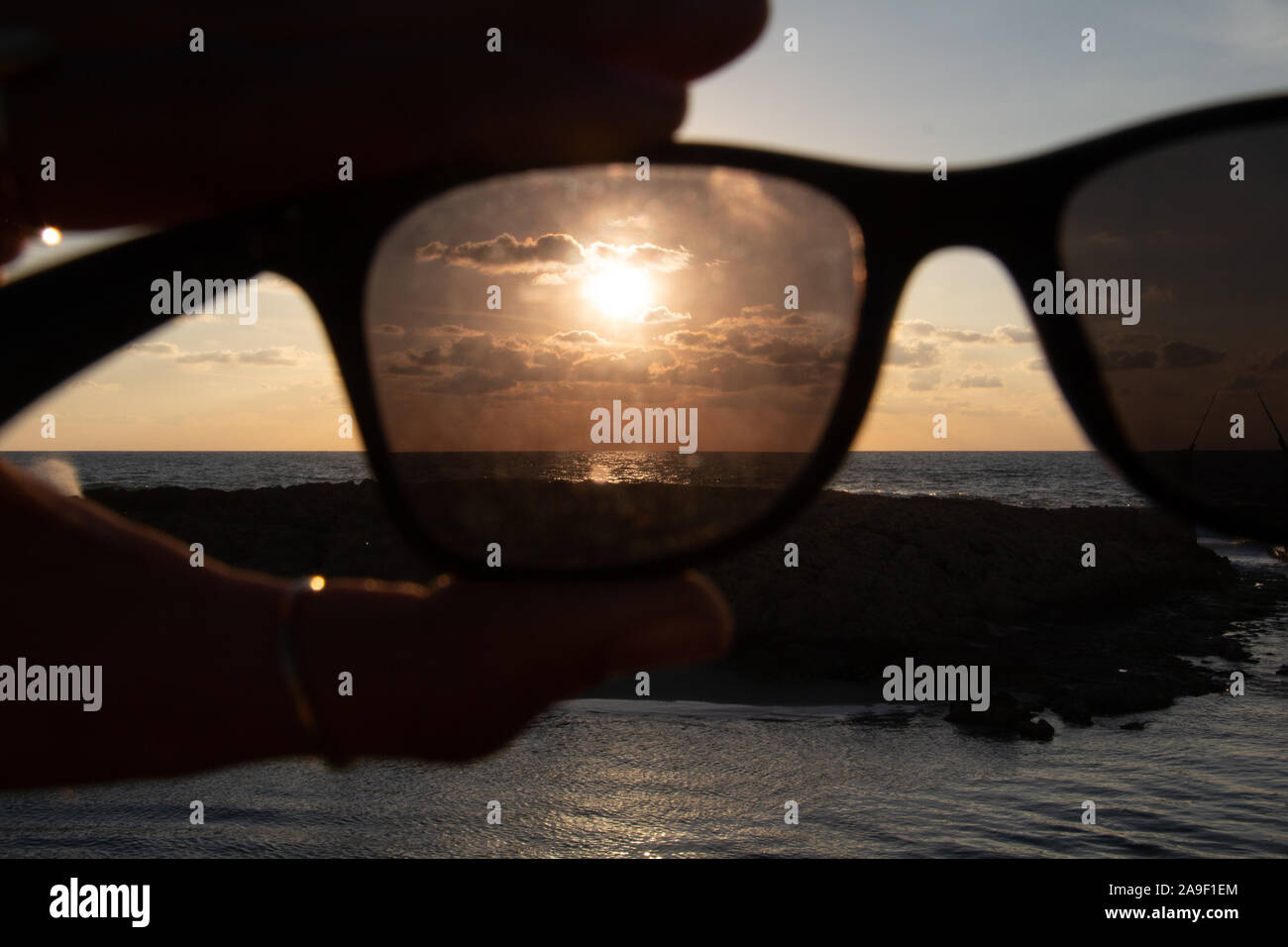 Godendo l'ultima luce del giorno con la fantastica vista del mare e i colori del tramonto rendono nel cielo Foto Stock