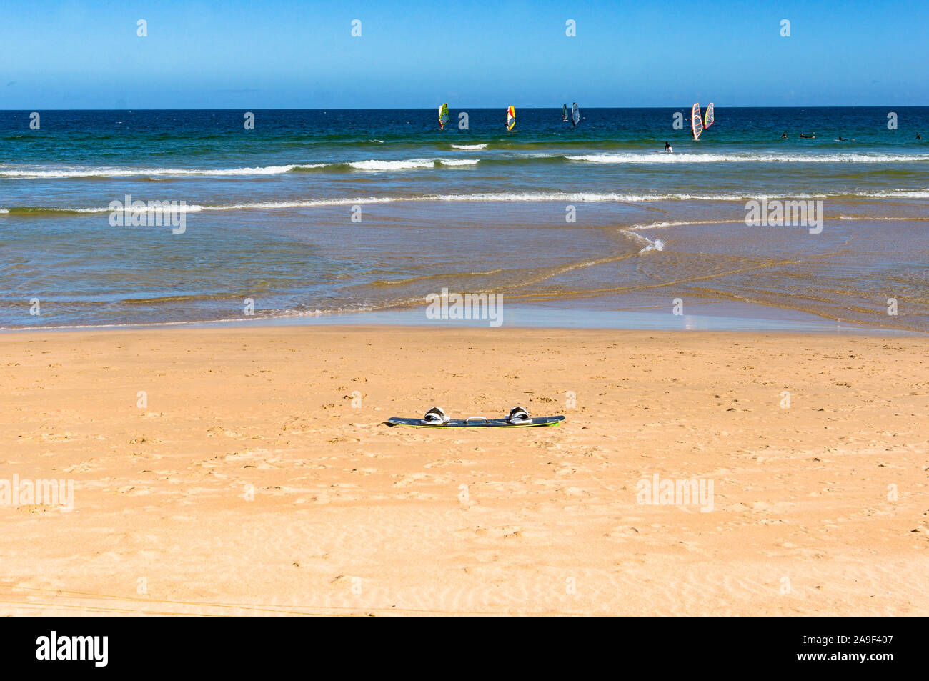 Tavola da Surf sulla sabbia con i surfisti sulle onde a distanza. Estate vacanze, sport d'acqua Foto Stock