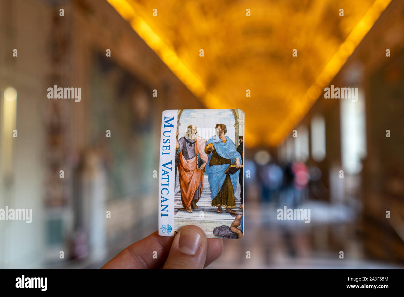 Un ragazzo in possesso di un biglietto per il Museo del Vaticano all'interno del museo. Bokeh bella, focuse è sul biglietto Musei Vaticani. Foto Stock