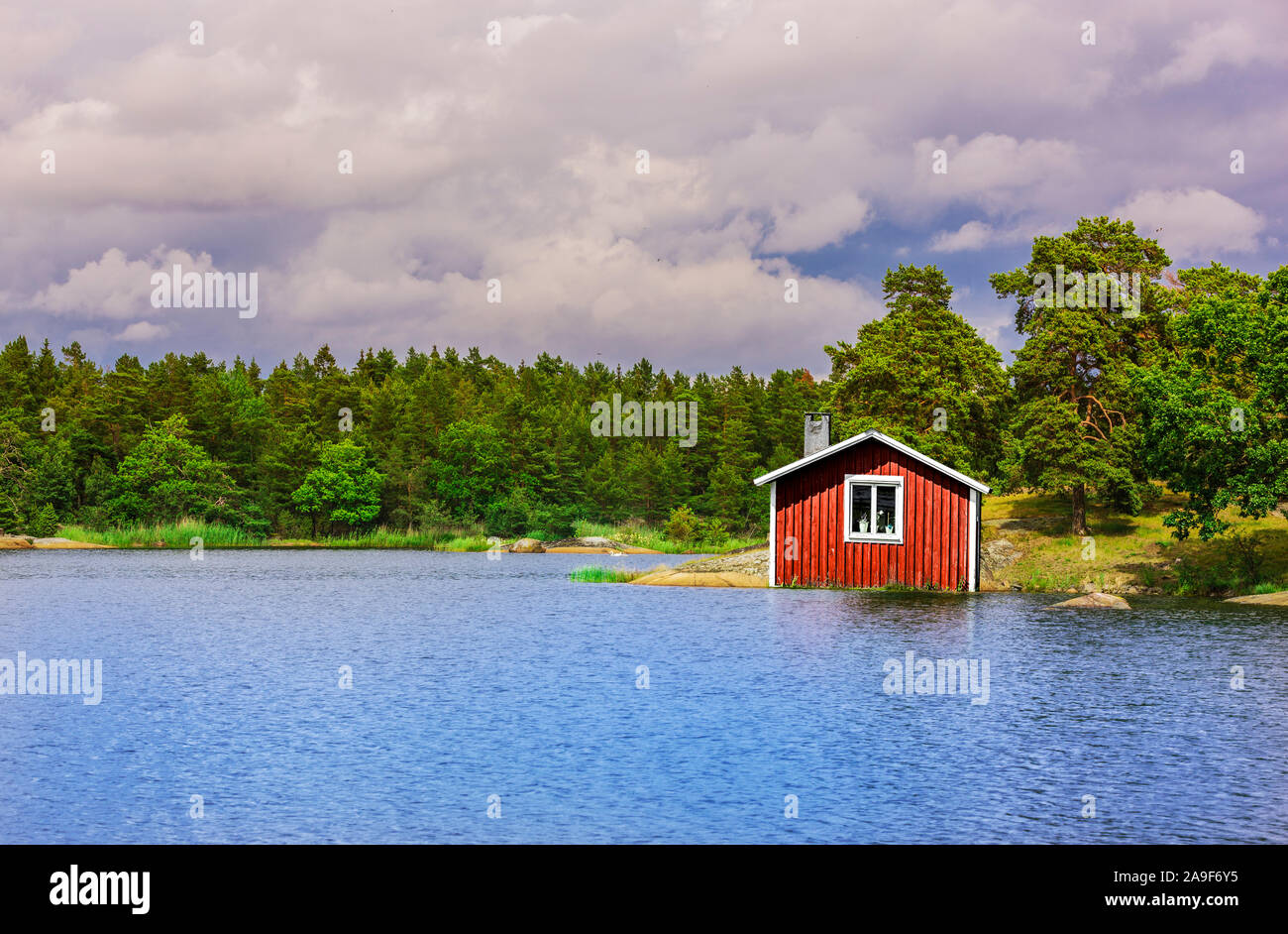 Red Svezia casa al lago Foto Stock