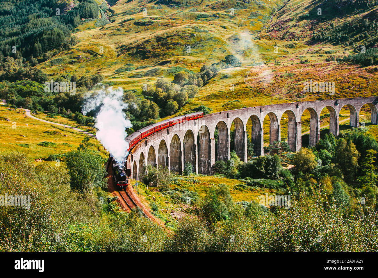 Il Giacobita treno a vapore, noto anche come il treno di Hogwarts come essa è stata usata nel film di Harry Potter franchise, viaggiando lungo il viadotto Glenfinnan Foto Stock