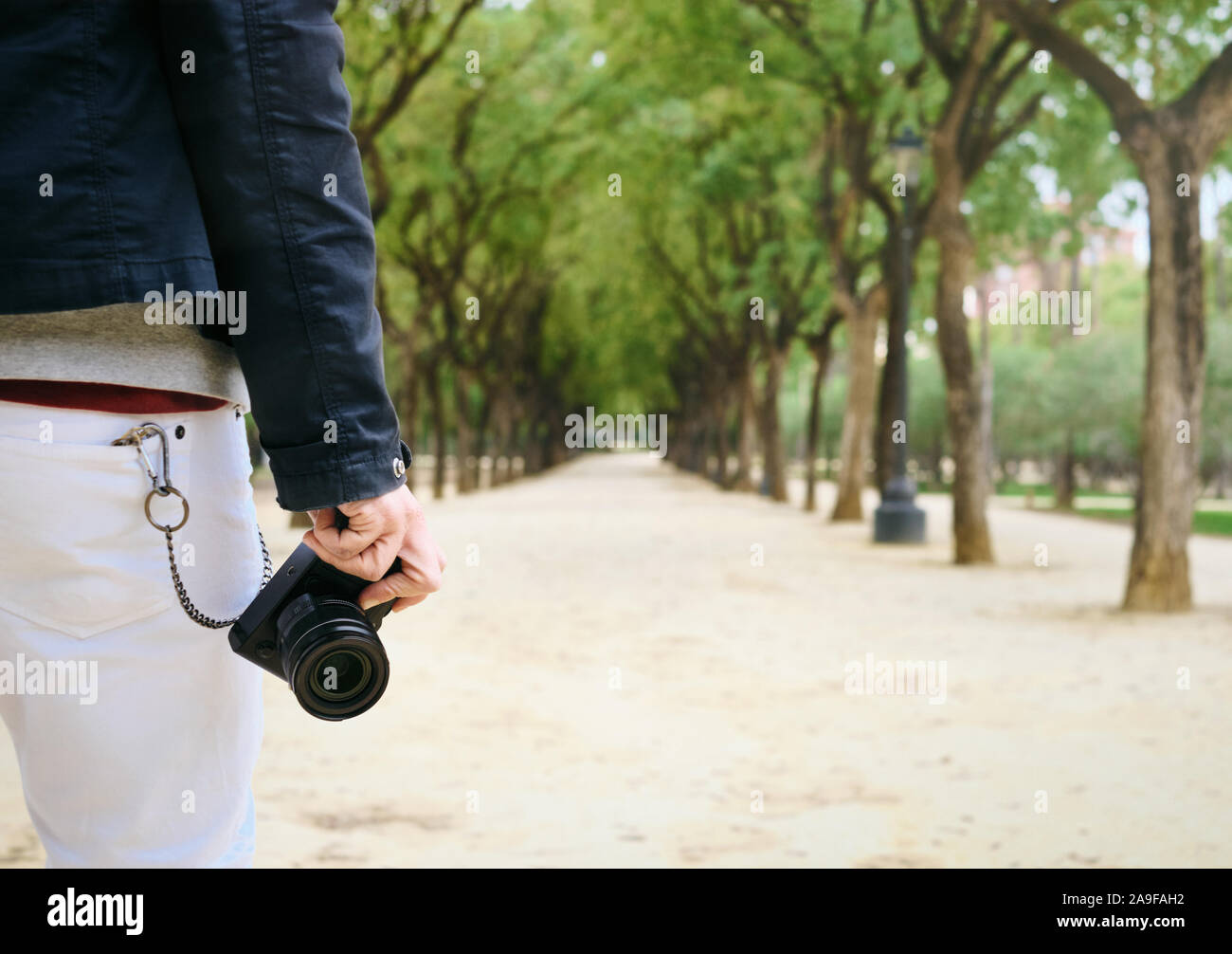 Tanga fotografo di strada a piedi con fotocamera Mirrorless in mano Foto Stock