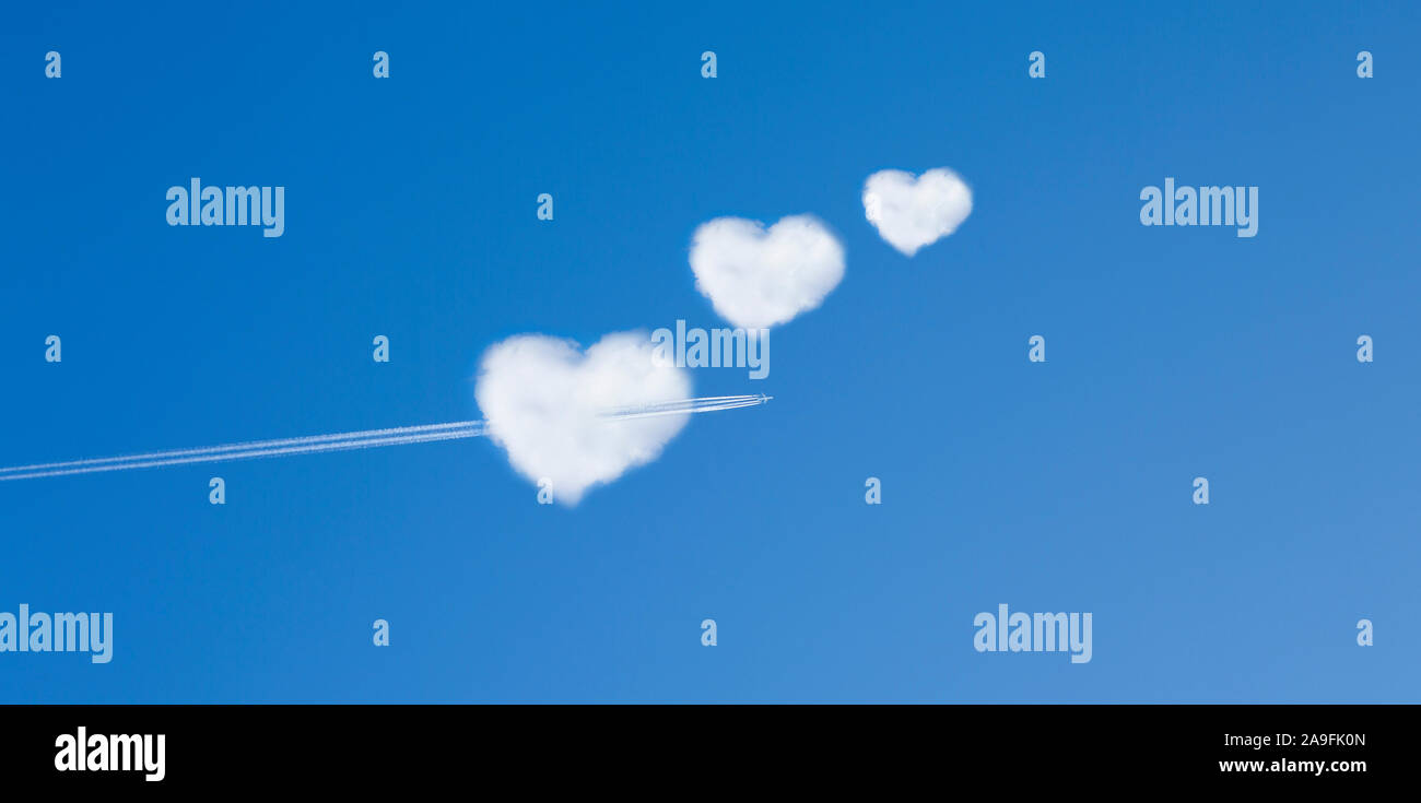 Aeroplano vola attraverso una forma di cuore il cloud Foto Stock