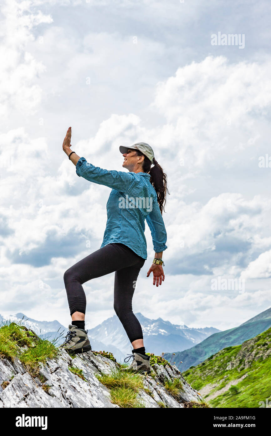 Donna in posa di vittoria su un picco di montagna Foto Stock