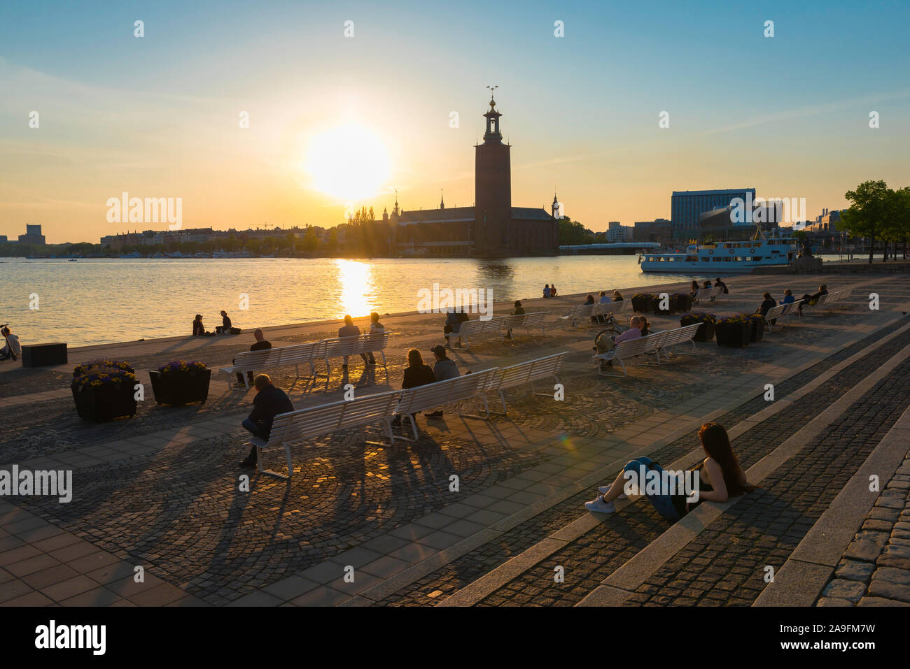 Stoccolma Svezia, vista della gente in estate rilassarsi sulla terrazza panoramica fronte mare di Riddarholmen guardando un tramonto su Kungsholmen, Stoccolma. Foto Stock