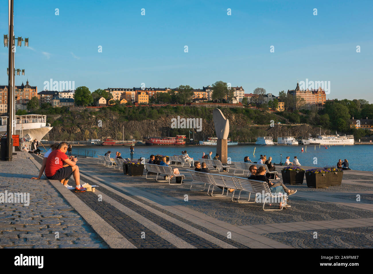 La città di Stoccolma, serata estiva vista di persone rilassante sulla spianata terrazza dell isola di Riddarholmen con vedute di Södermalm, Stoccolma centrale. Foto Stock