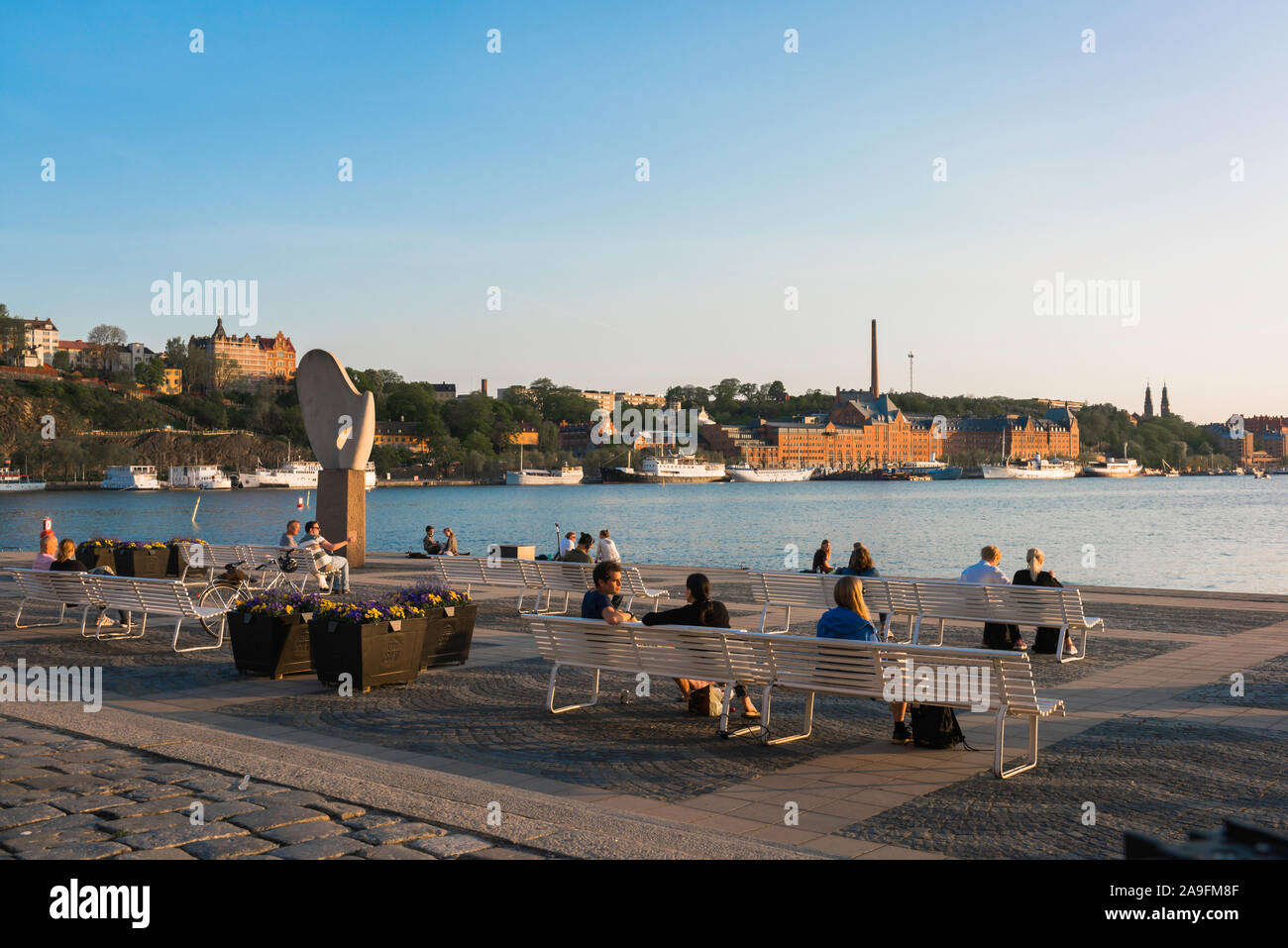 Stoccolma serata estiva, vista di persone rilassante sulle panchine situate sulla spianata di isola di Riddarholmen con vedute di Södermalm, Stoccolma centrale. Foto Stock