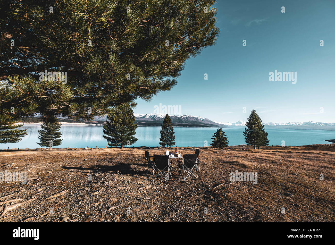 Tavolo per la colazione vicino al lago blu e le montagne nella parte posteriore Foto Stock