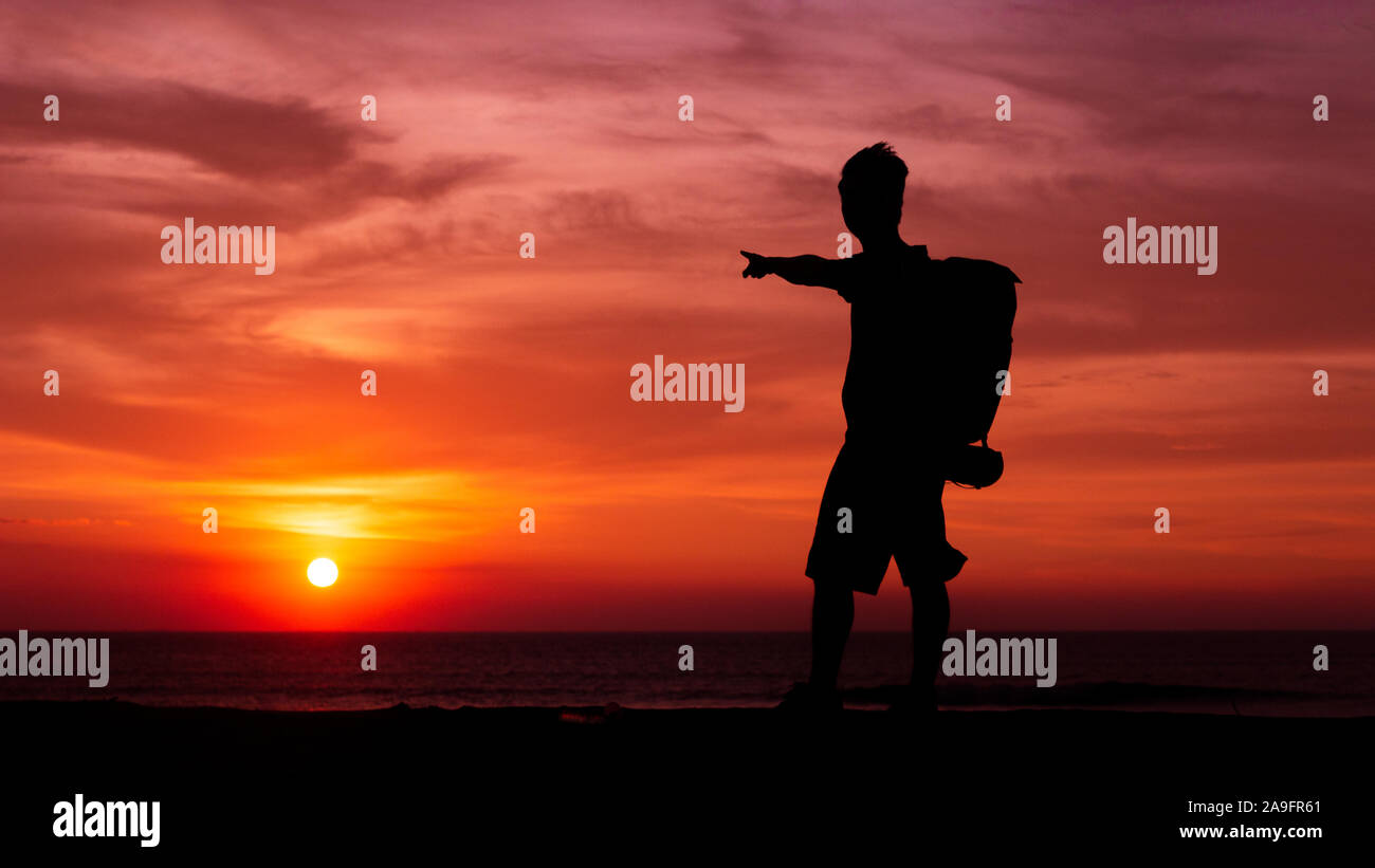 L'uomo sul tramonto dopo aiutare baby turttles andare all'oceano Foto Stock