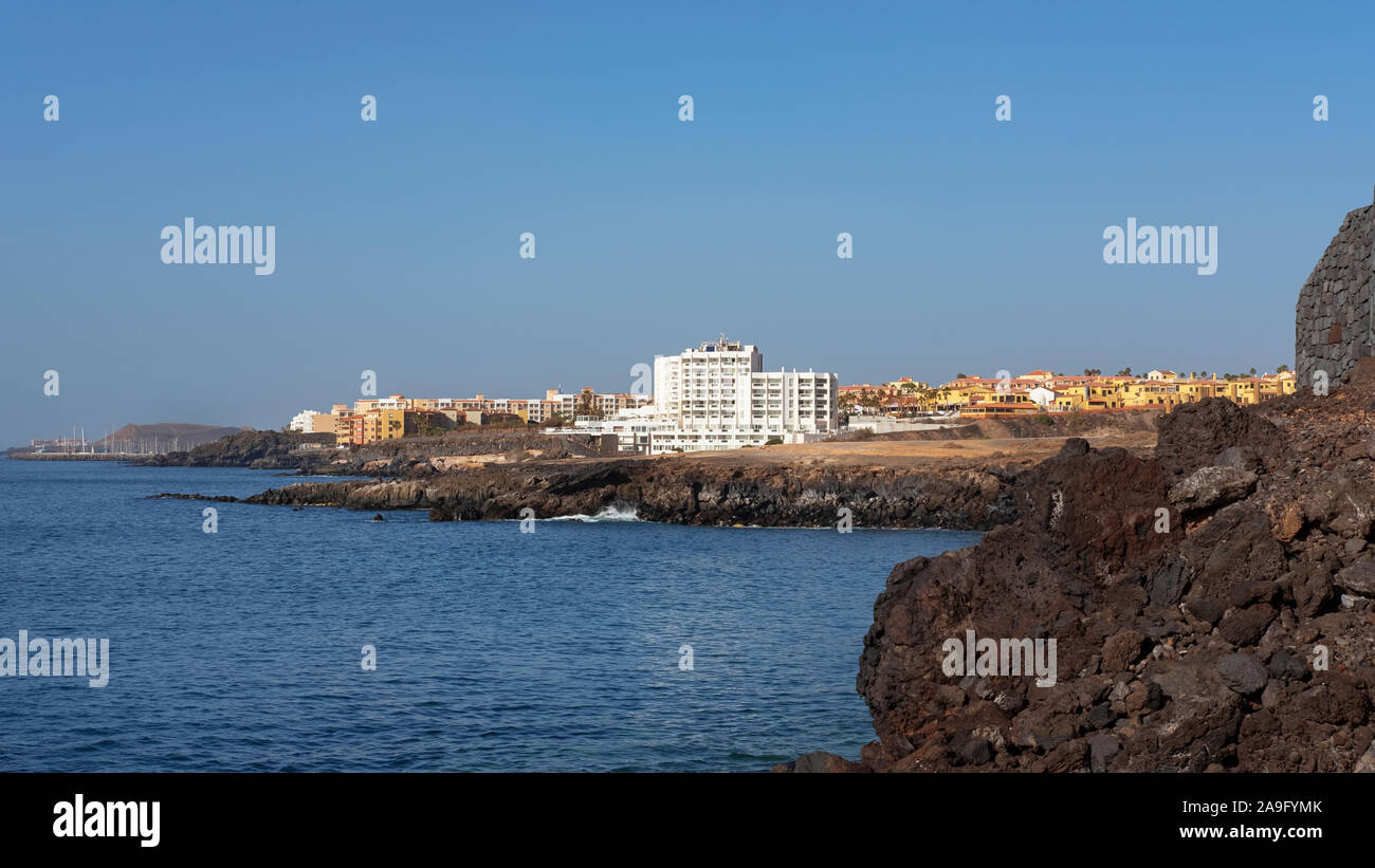 Estate chiaro vistas verso San Blas e Golf del Sur, popolare località del sud di Tenerife, come si vede dalla Playa Grande nel piccolo villaggio di Los Abrigos Foto Stock