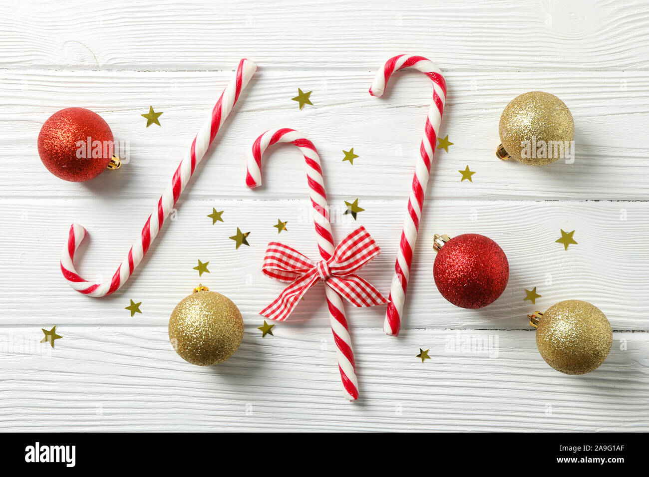 Candy canne e accessori di natale in bianco sullo sfondo di legno, lo spazio per il testo Foto Stock