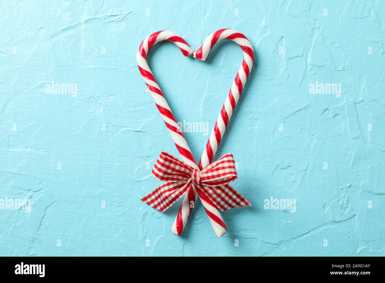 Caramella dolce canne con archetti su sfondo blu, spazio per il testo Foto Stock