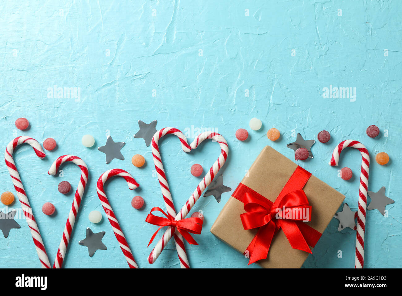Candy canne e accessori di natale su sfondo blu, spazio per il testo Foto Stock