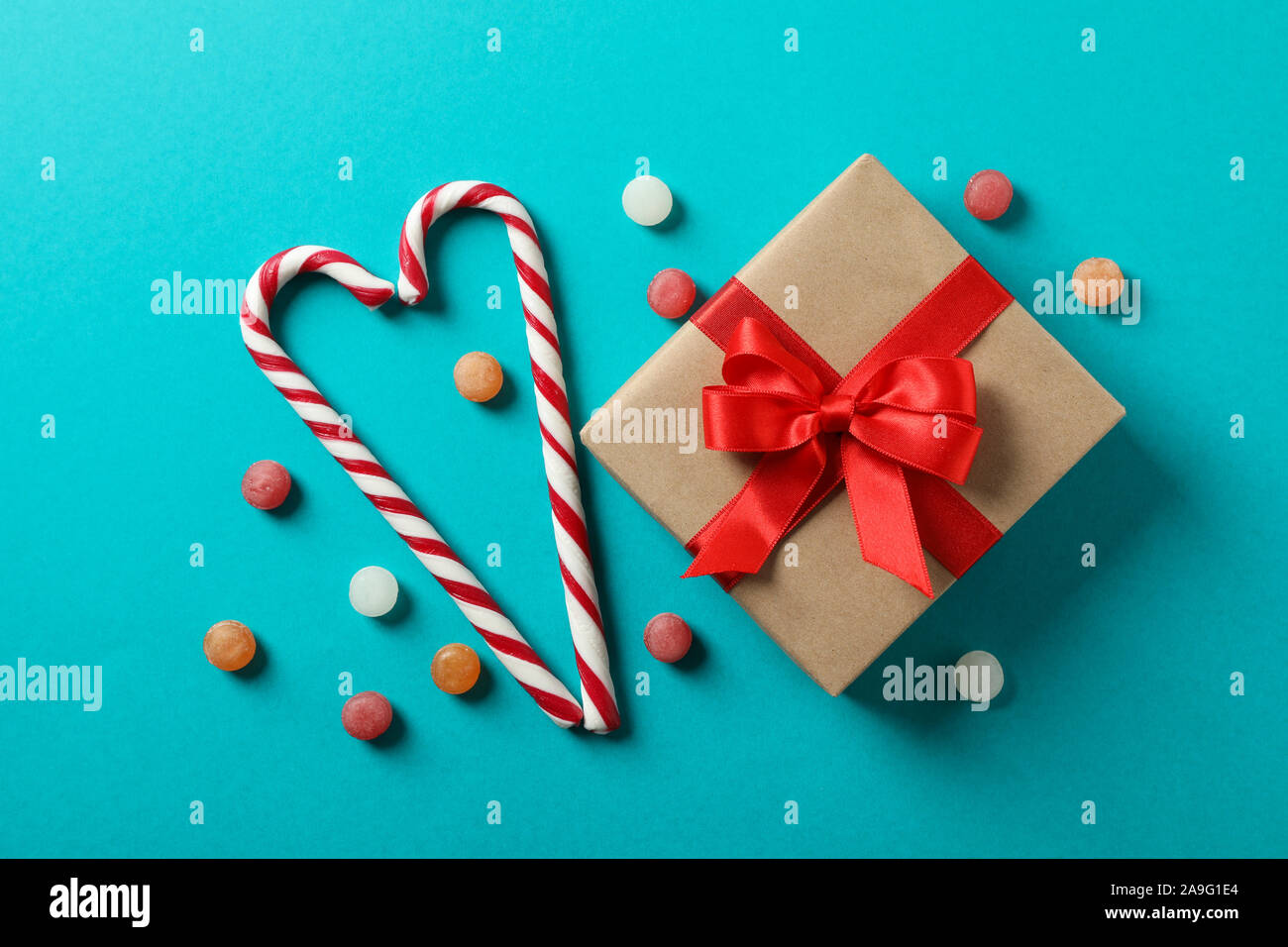 Caramella dolce canne e confezione regalo su sfondo turchese, spazio per il testo Foto Stock