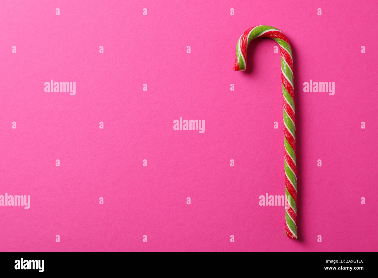 Dolce candy cane su sfondo rosa, spazio per il testo Foto Stock