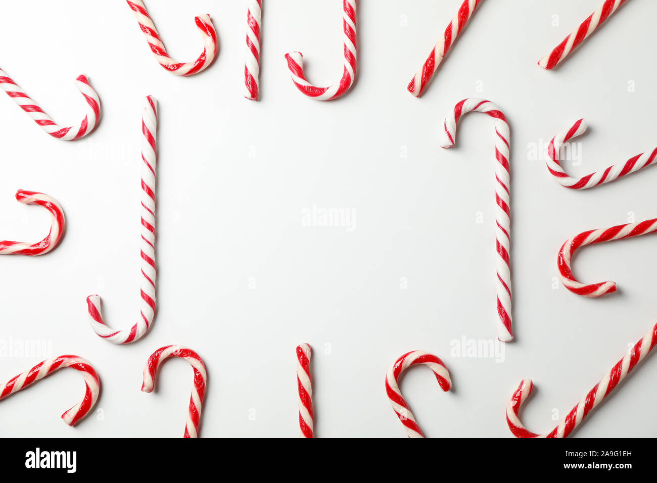Composizione con caramella dolce canne su sfondo bianco, spazio per il testo Foto Stock
