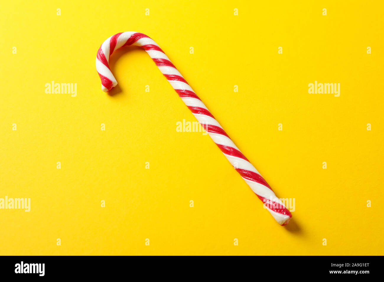 Dolce candy cane su sfondo giallo, spazio per il testo Foto Stock