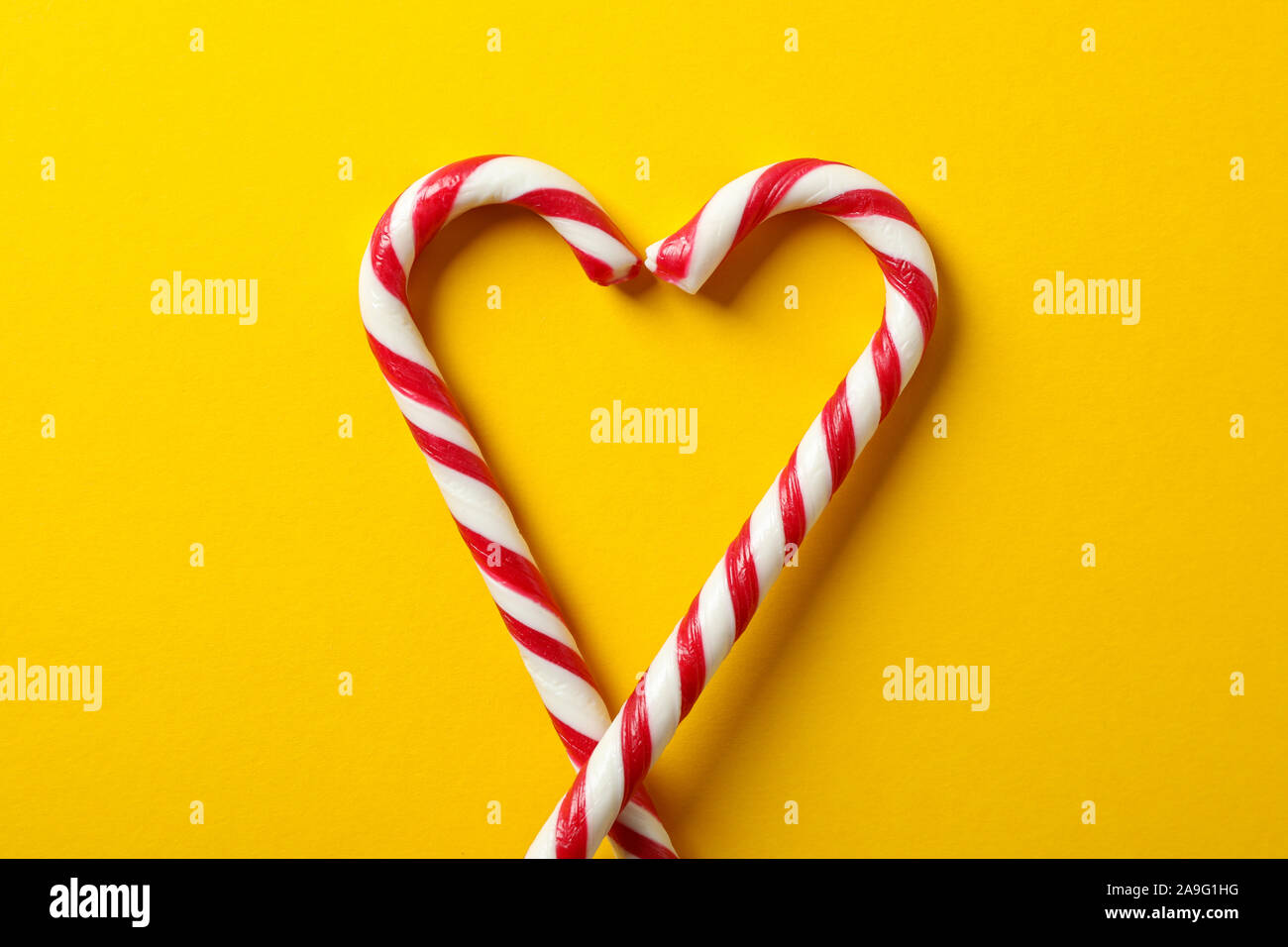 Dolce candy canes su sfondo giallo, spazio per il testo Foto Stock