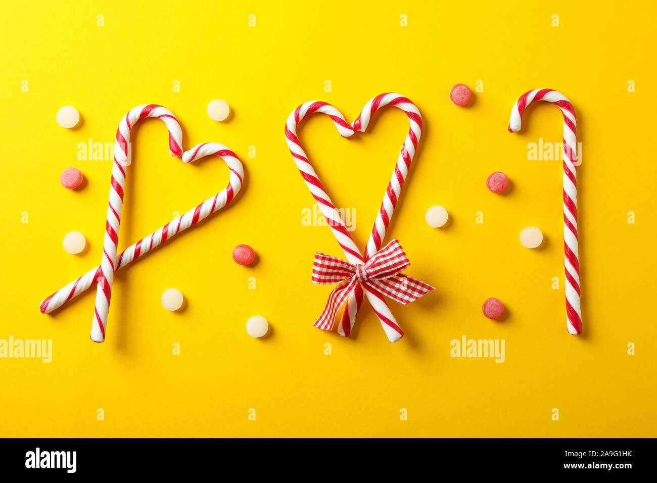 Piano di composizione dei laici con la caramella canne su sfondo giallo, spazio per il testo Foto Stock