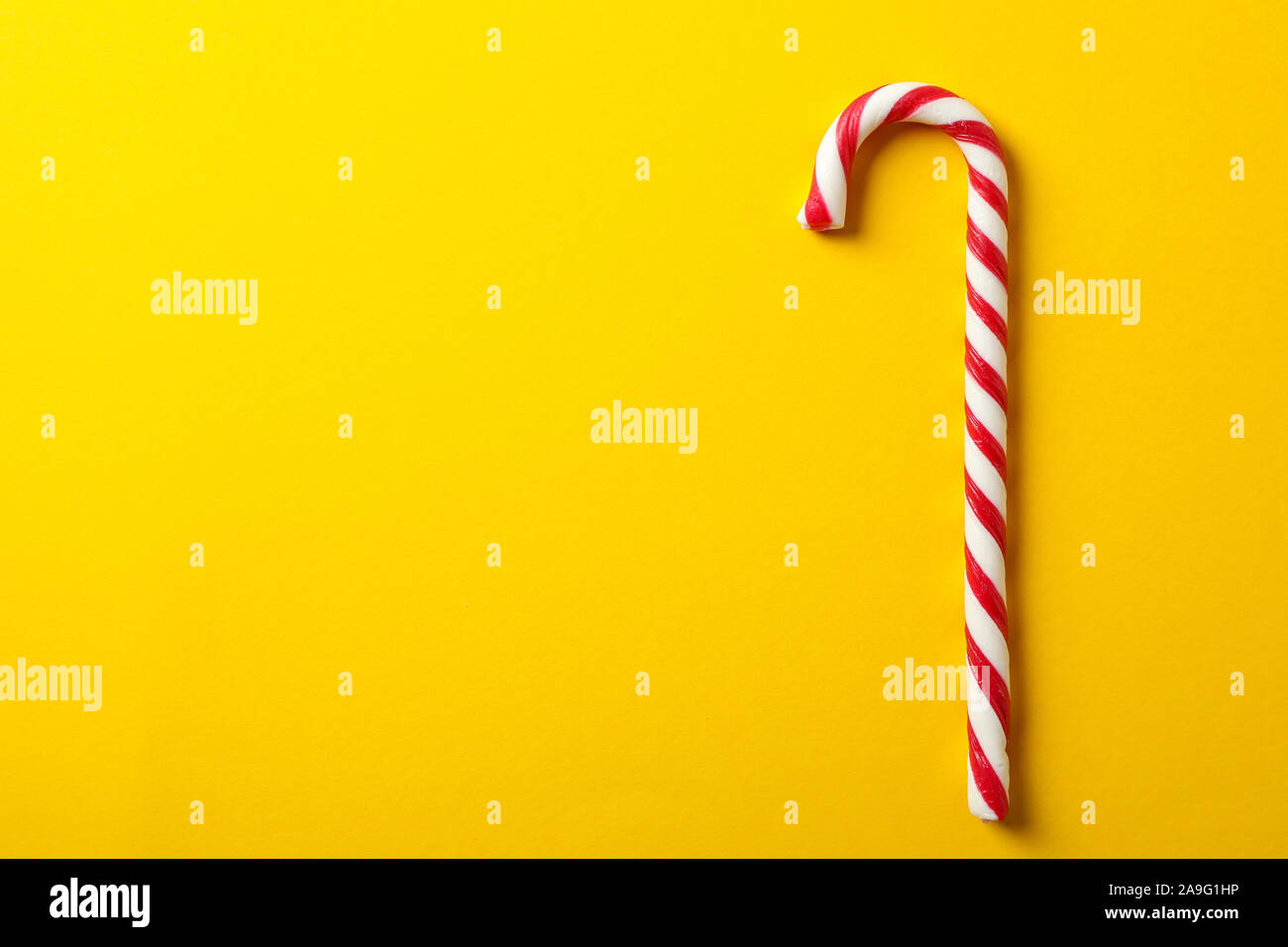 Dolce candy cane su sfondo giallo, spazio per il testo Foto Stock