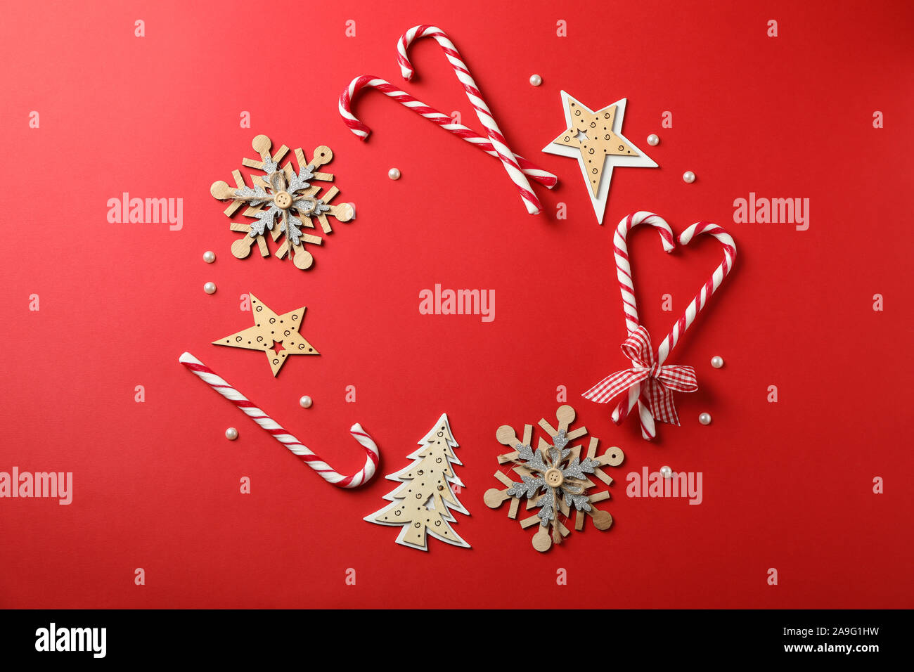 Candy canne e accessori di natale su sfondo rosso, lo spazio per il testo Foto Stock