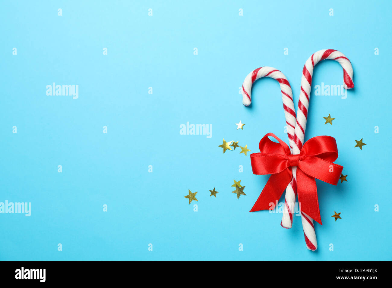 Caramella dolce canne e arco sul colore di sfondo, spazio per il testo Foto Stock
