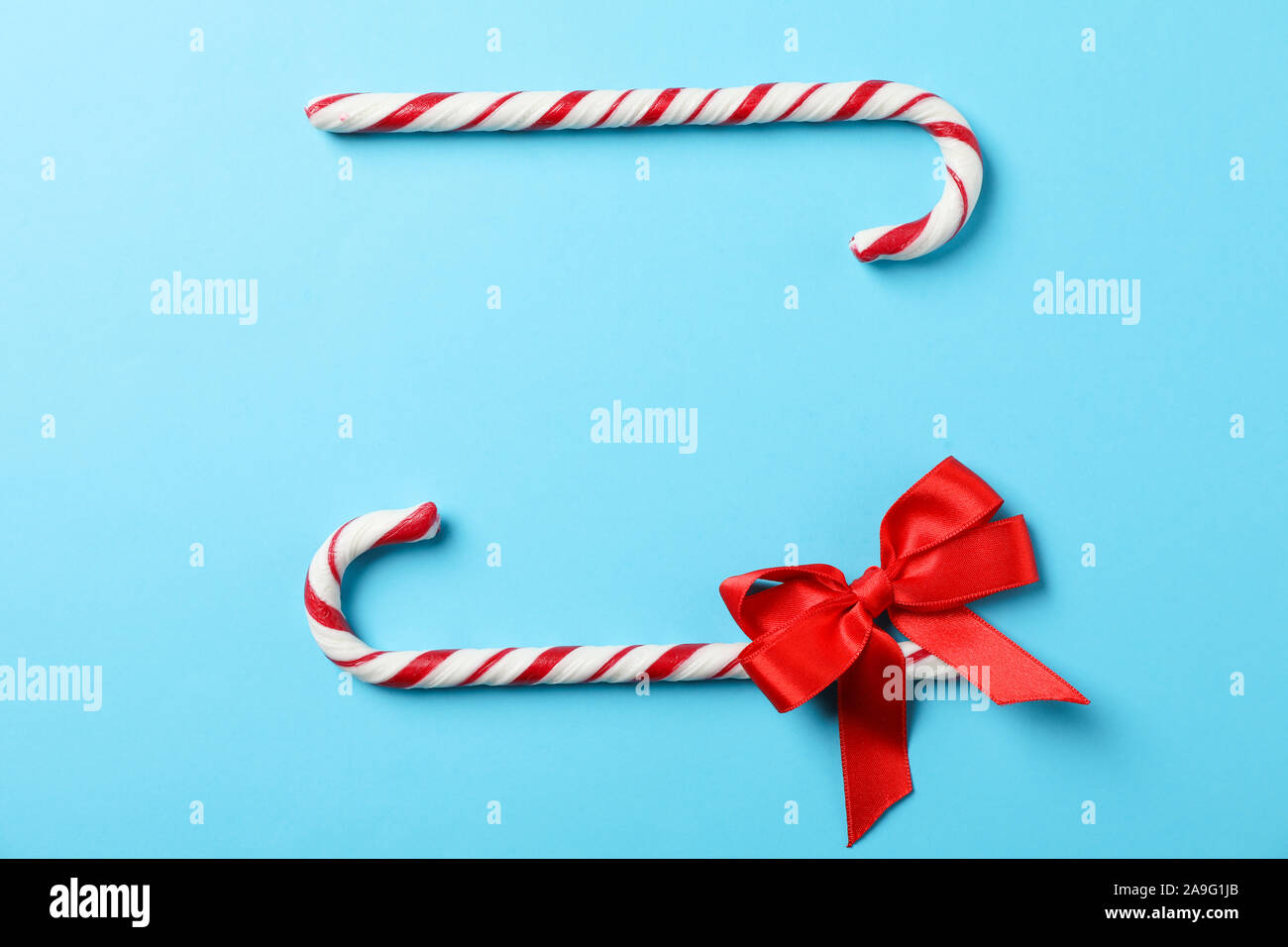 Caramella dolce canne e arco sul colore di sfondo, spazio per il testo Foto Stock